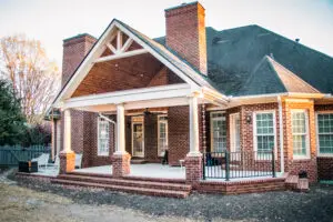 custom home exterior featuring covered porch, roofline detail, custom exterior craftsmanship in greenville, south carolina