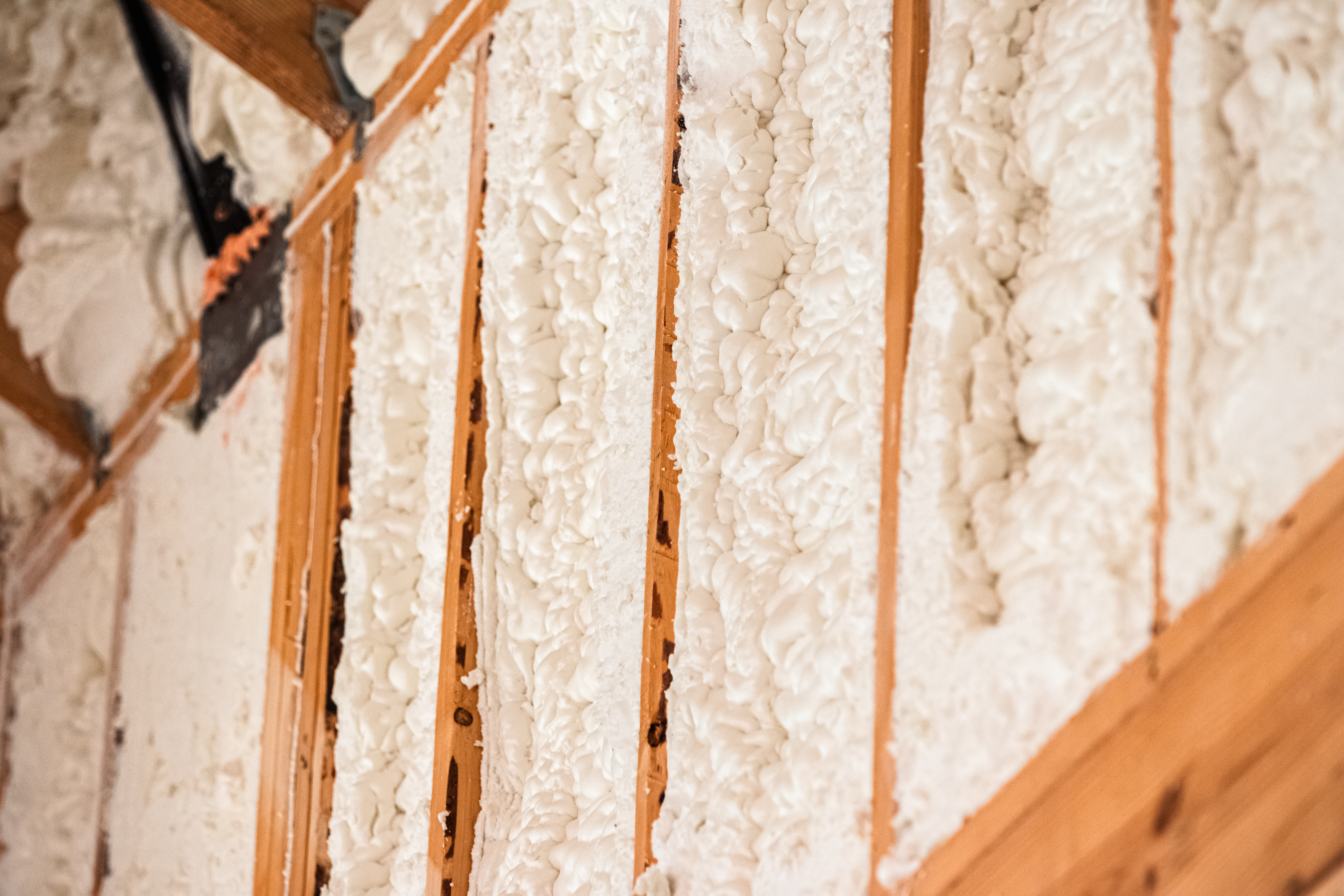 Spray foam insulation applied between wall studs for thermal performance